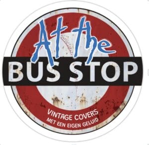 Rond bord met in vetgedrukte letters de tekst „At the BUS STOP”, daaronder „VINTAGE COVERS MET EEN EIGEN GELUID” en een verweerde rode, witte en zwarte achtergrond.